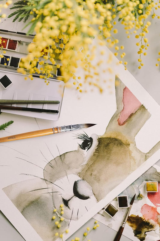 Delicate watercolor painting of a rabbit surrounded by flowers on cold press paper